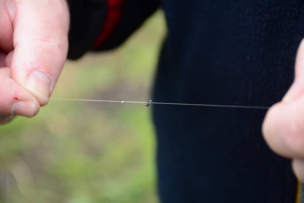 Een knoopje in het uiteinde van de lijn, door van een lusje (achtknoop) de lus en uiteinden weg te knippen. De onderlijn ‘lasso’ je vervolgens om deze knoop.